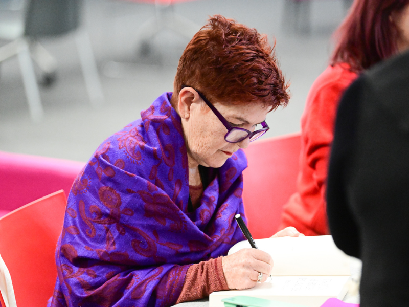 Image of woman sitting at table writing.